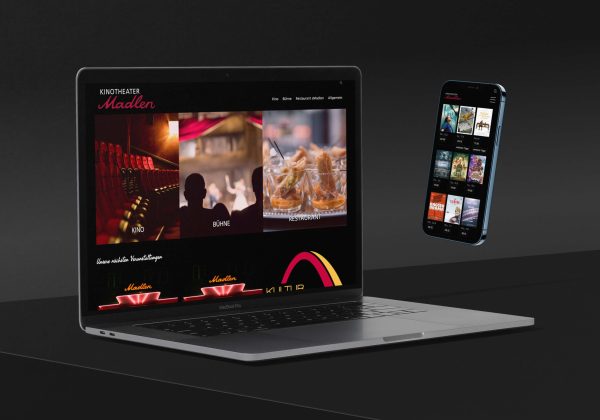 Ein MacBook und ein Smartphone auf denen die Website des Kinotheater Madlen geöffnet ist